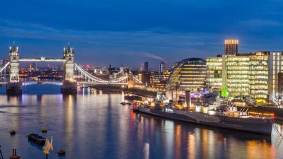 Tower Bridge against a clear sky, viewed from Halkin with London skyline in the background, iconic architecture in focus.