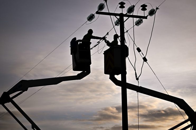 UK energy power lines spanning a rural landscape, highlighting infrastructure and sustainability efforts in the energy sec...