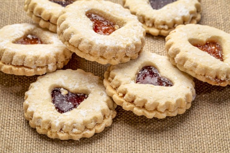 Freshly baked golden biscuits on a baking tray, showcasing a variety of shapes and textures, ideal for a breakfast feature