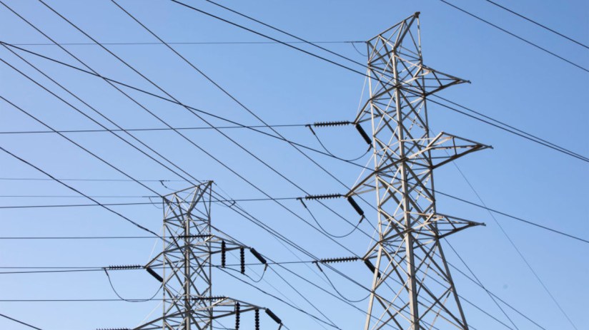 Pylons standing tall against a clear sky following Engies acquisition of UK Power Networks, symbolizing energy sector growth.