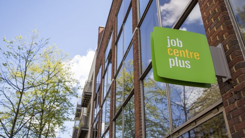 People outside a Job Centre Plus office, discussing employment opportunities and services in the current job market.
