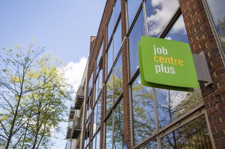 People outside a Job Centre Plus office, discussing employment opportunities and services in the current job market.