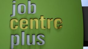 Business executives discussing corporate restructuring amid job cuts in modern office setting, reflecting economic challenges