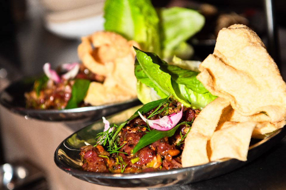 Khao bird food packaging displaying nutritional information and vibrant images of birds in a garden setting