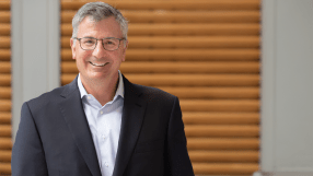 Erik Hirsch, private credit executive, discussing financial strategies at a business conference podium with a focused audi...