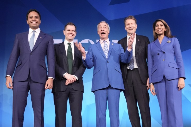 Shadow Cabinet members discussing reform strategies at a conference table with documents and laptops in a modern office se...