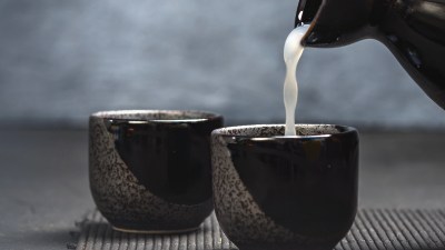 Traditional sake brewing process in Japan showcasing artisans crafting sake using rice, water, and koji in a historic brewery