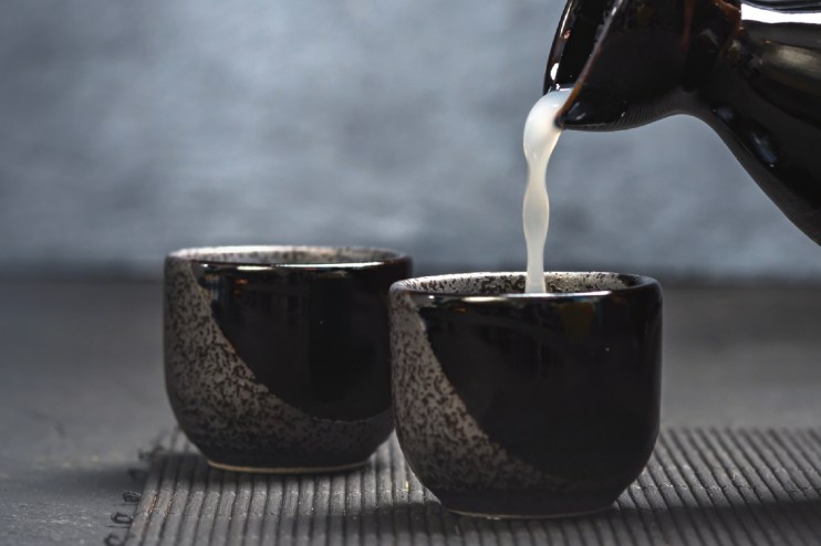 Traditional sake brewing process in Japan showcasing artisans crafting sake using rice, water, and koji in a historic brewery
