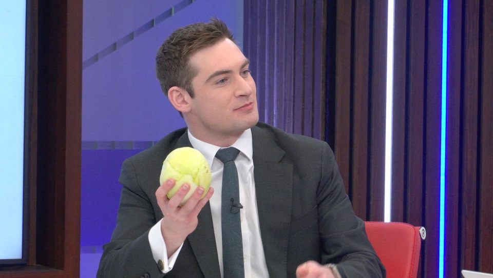 Tom Harwood in professional attire discussing current events in a newsroom setting