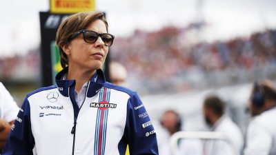 Breaking news event with a large crowd gathered in a city square, diverse attendees holding signs and banners, urban backdrop