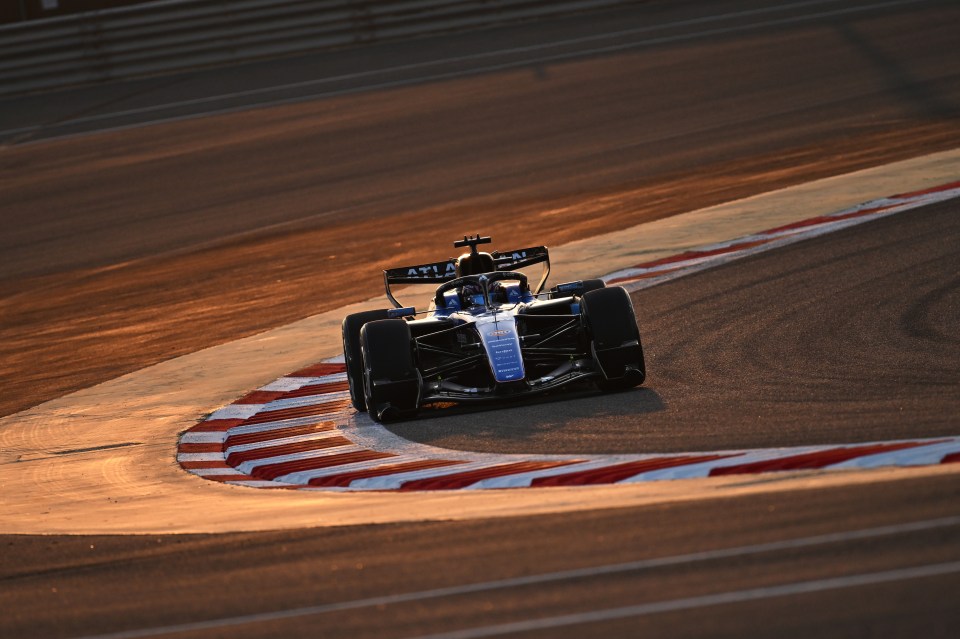 Alex Albon racing on track in Formula 1 car, showcasing speed and precision on a sunny day during competitive event.
