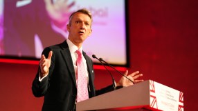 Andy Haldane, British Chambers of Commerce president, addressing a business conference, wearing a suit and tie.