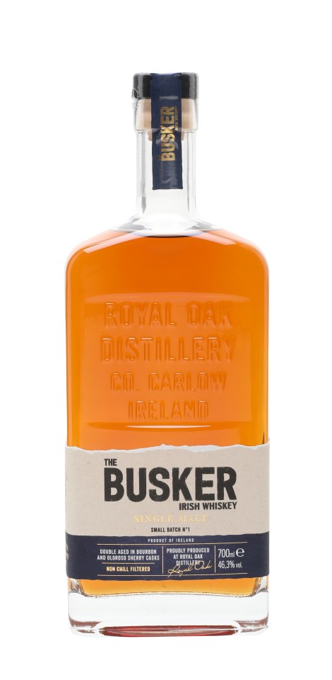Busker Small Batch Single Malt Irish Whiskey bottle with elegant label design on a wooden surface in a cozy setting
