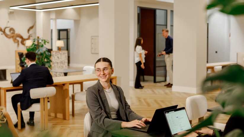 Modern coworking space with diverse professionals collaborating at desks, fostering creativity and productivity in a share...