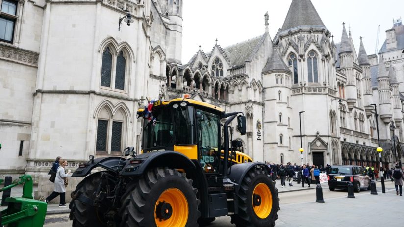 Farmers rally outside high court, holding protest signs and banners, advocating for agricultural rights and policy changes.