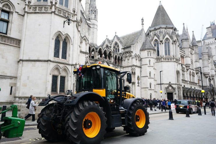 Farmers rally outside high court, holding protest signs and banners, advocating for agricultural rights and policy changes.