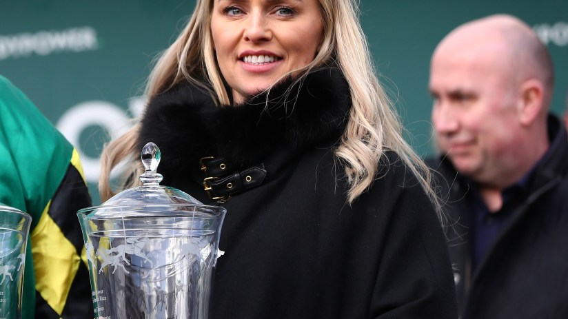 Business professionals in a modern conference room discussing strategies with a digital presentation on a large screen.