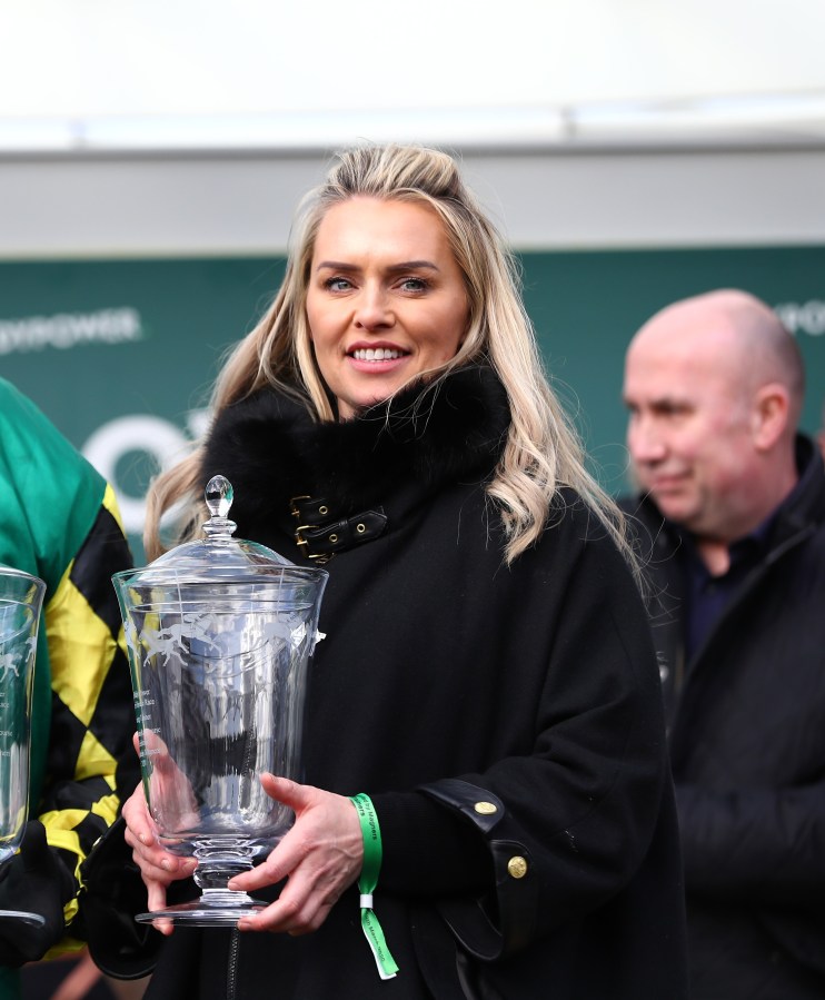 Business professionals in a modern conference room discussing strategies with a digital presentation on a large screen.