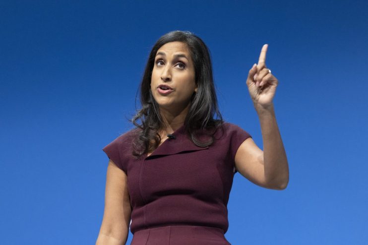 GettyImages 2239538685 showing business professionals in a meeting, discussing financial strategies, with charts and lapto...