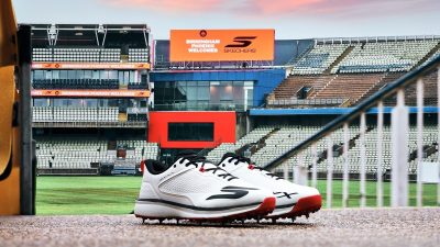 Breaking news concept with a digital clock showing the time, surrounded by scattered newspapers and a laptop on a desk