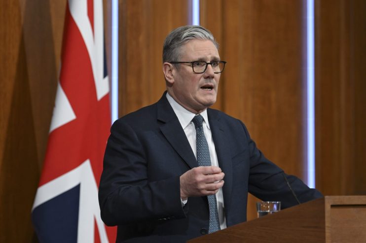 Keir Starmer delivering a speech at a public event, emphasizing policy changes and leadership strategies, with a focused a...