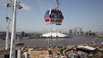 Greenwich London cable car over River Thames with city skyline, highlighting urban transport and scenic views