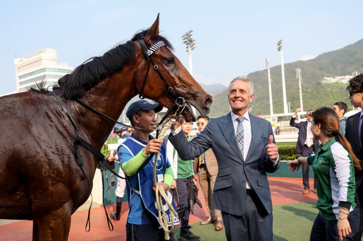 Mark Newnham in a business suit, presenting at a conference podium, engaging with an audience in a professional setting