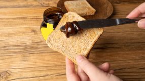 Marmite jar on a breakfast table with fresh bread and butter, highlighting its distinctive branding and popular breakfast ...
