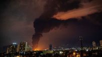 Damaged oil facility in Iran with smoke and debris following a strike, highlighting impact on energy infrastructure and re...