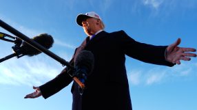 President Trump delivering a speech at a podium, emphasizing national policies, with American flags in the background.