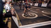 Cyclists racing through city streets at night during Rapha Nocturne event, showcasing vibrant urban cycling culture.