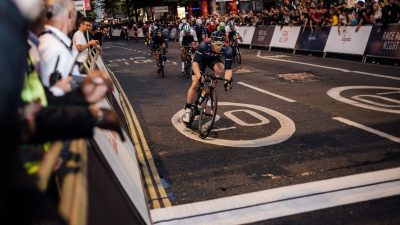 Cyclists racing through city streets at night during Rapha Nocturne event, showcasing vibrant urban cycling culture.