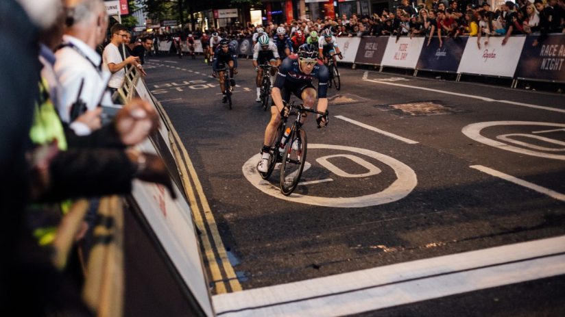 Cyclists racing through city streets at night during Rapha Nocturne event, showcasing vibrant urban cycling culture.