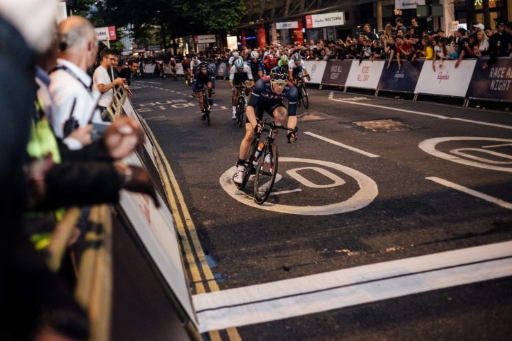 Cyclists racing through city streets at night during Rapha Nocturne event, showcasing vibrant urban cycling culture.