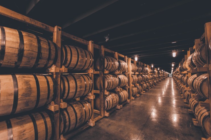 Single barrel rickhouse showcasing neatly arranged wooden barrels in a spacious storage facility for aging spirits.