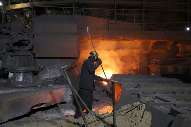 Steel manufacturing process showcasing molten steel being poured in a foundry, highlighting industrial production techniques.