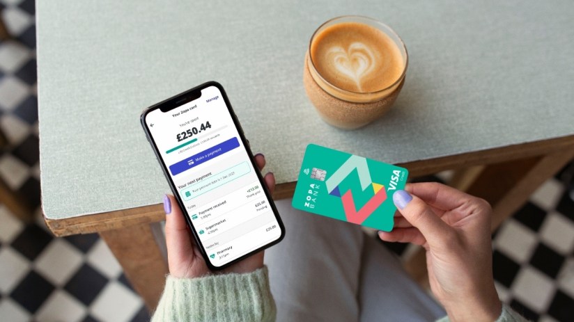 Woman using Zopa Bank credit card and smartphone app, demonstrating digital banking on-the-go features.
