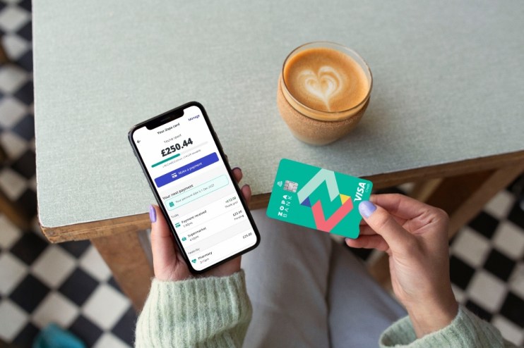 Woman using Zopa Bank credit card and smartphone app, demonstrating digital banking on-the-go features.