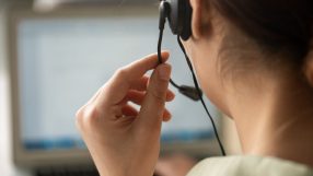 Busy call centre with diverse team of customer service representatives using headsets and computers to assist clients