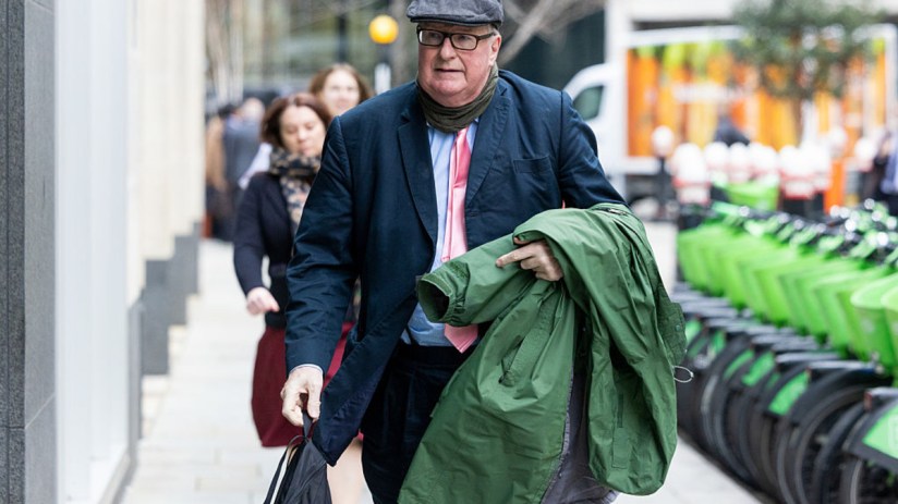 Crispin Odey entering court in a formal suit, capturing a pivotal moment in a high-profile legal proceeding.
