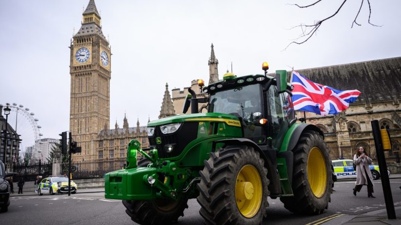 Farmers gathered in protest holding banners and signs, advocating for agricultural rights and policy reforms in rural sett...