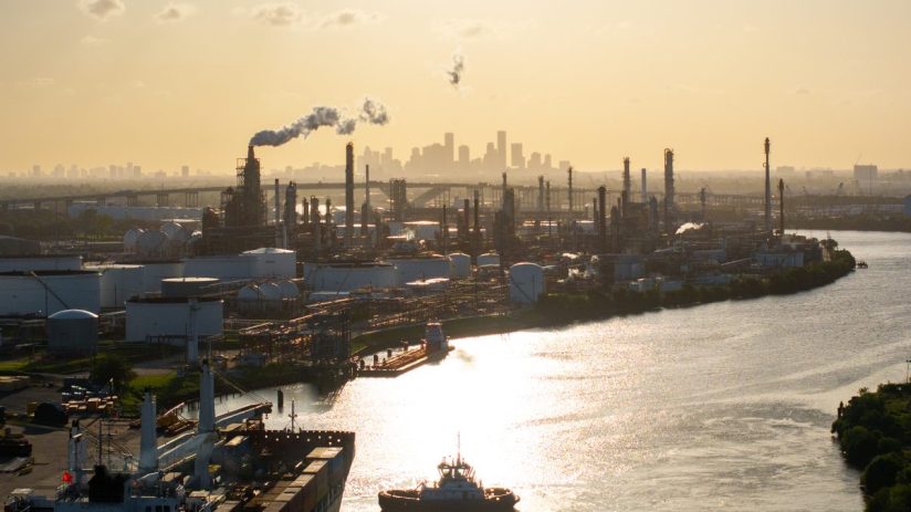 Sprawling oil refinery with complex network of pipes and towers under a clear sky, highlighting industrial energy production.
