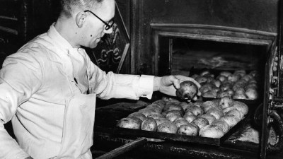 Freshly harvested potatoes piled in a field, showcasing their earthy texture and rich, natural colors against a rural back...
