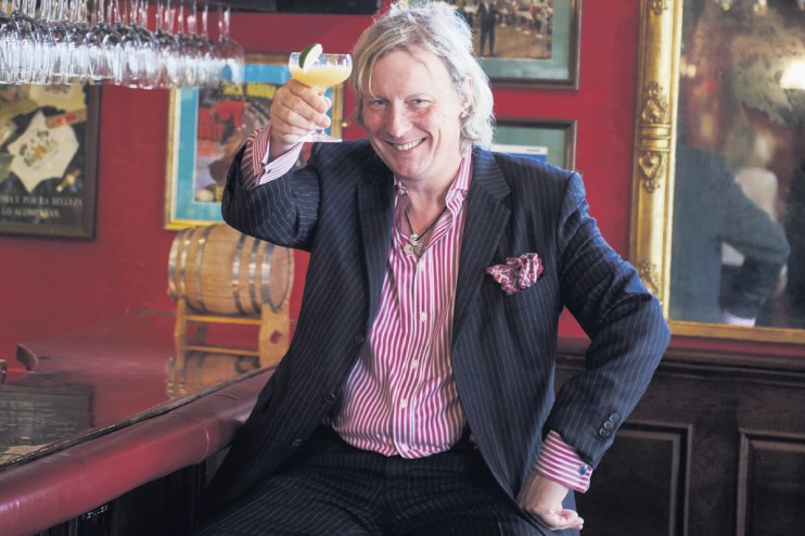 Ranald presenting at a business conference, emphasizing key strategies in a suit and tie, engaging with a diverse audience