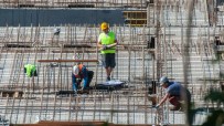 Busy construction site with cranes and workers building a new structure, showcasing urban development progress