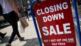 Closed sign hanging on small business door, symbolizing temporary closure or operational pause amid challenging market con...