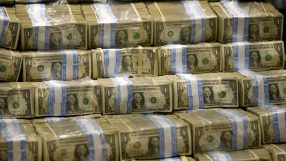 Close-up view of US dollar bills fanned out, highlighting currency detail, representing economic and financial news topics.