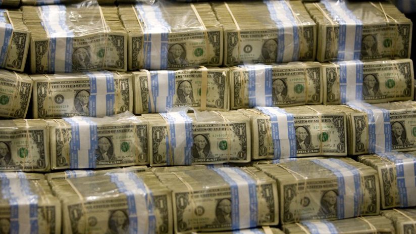 Close-up view of US dollar bills fanned out, highlighting currency detail, representing economic and financial news topics.