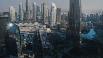 Dubai skyline featuring iconic skyscrapers and modern architecture under a clear blue sky, showcasing the citys urban land...