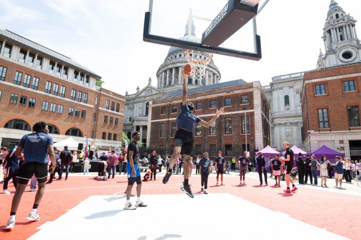 Business professionals discussing strategy in a modern conference room with digital presentations and diverse team members.